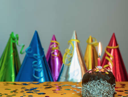 Cake with a candle and colorful caps.の写真素材