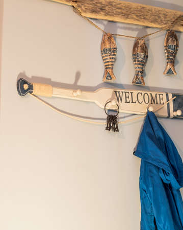 The jacket is hanging in the hallway on a hanger in the shape of an oarの写真素材