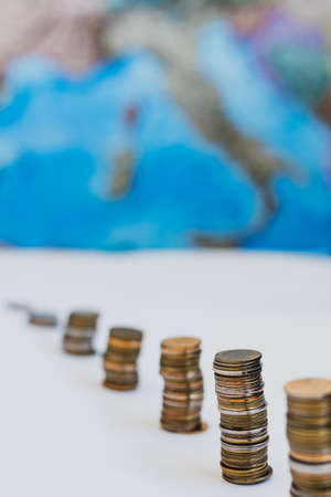 Coins in the form of a falling chart on a background of a map of Europeの写真素材