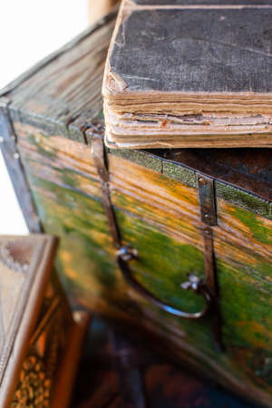 Old book lying on the chest, light from the window.の写真素材