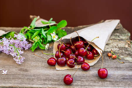 Cherry and flowers on a wooden craft table.