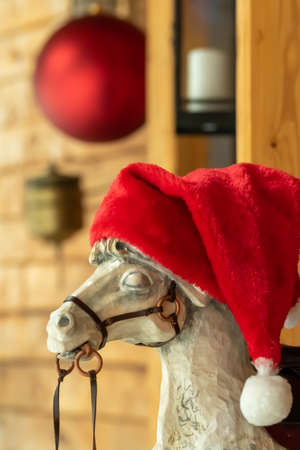 Wooden rocking horse in a New Years cap at the entrance to the house.の写真素材
