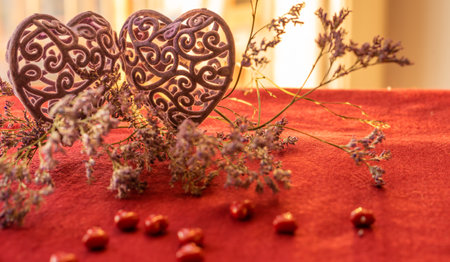 Two hearts and limonium flower on a red tableclothの写真素材