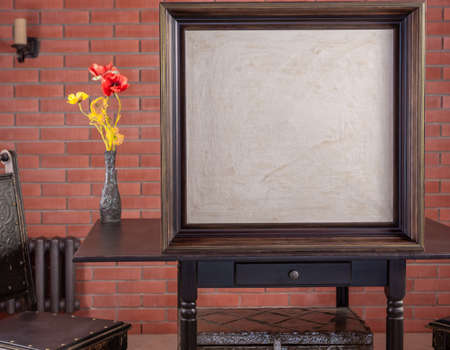 Frame with blank white canvas on tableの写真素材