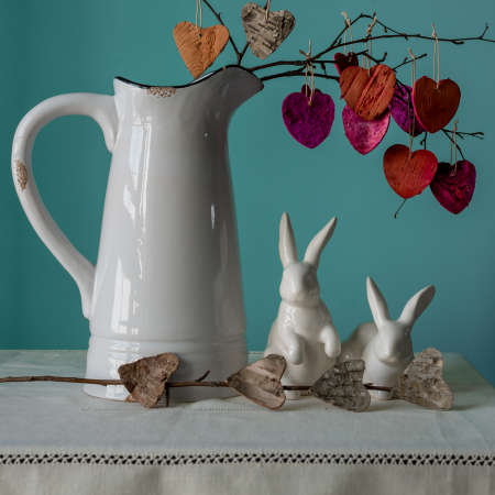 A twig with hearts in a jug and two porcelain haresの写真素材