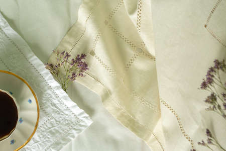 Cup of coffee on a white sheet. Coffee in bed. Flat layの写真素材