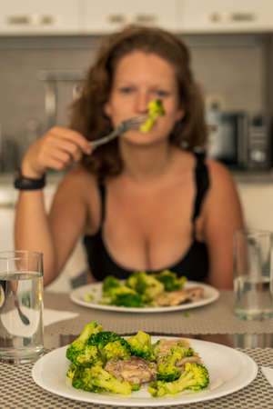 Plate with broccoli cabbage, girl in the background having lunchの写真素材