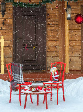 New Year's decorations with a red table and chairs in front of the house entrance.の写真素材