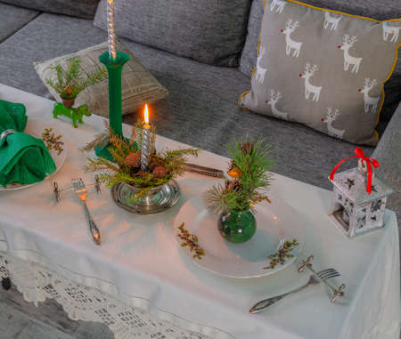 New Years table setting with linen tablecloth, candles and spruce branchesの写真素材
