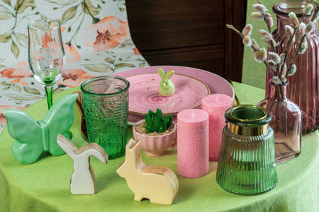 Beautiful round table with decorations in the dining room. Figure of a rabbit, glassware, willow twigsの写真素材