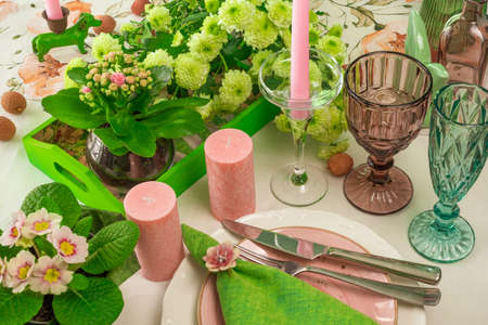 Romantic spring table setting for two with wine glasses, candles and flowersの写真素材