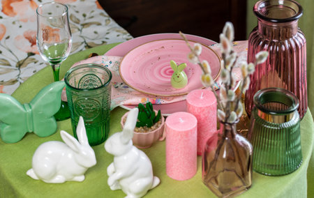 Beautiful round table with decorations in the dining room. Figure of a rabbit, glassware, willow twigsの写真素材