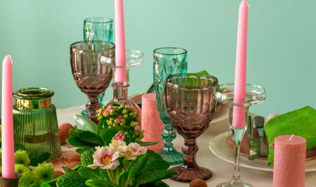 Romantic spring table setting for two with wine glasses, candles and flowers.の写真素材