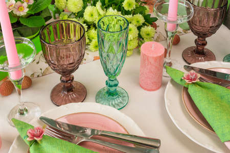 Romantic spring table setting for two with wine glasses, candles and flowers.の写真素材