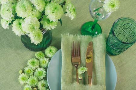 Spring table setting in green tone with flowersの写真素材