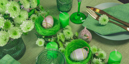 Set table with Easter decoration - eggs in nests and flowers.の写真素材