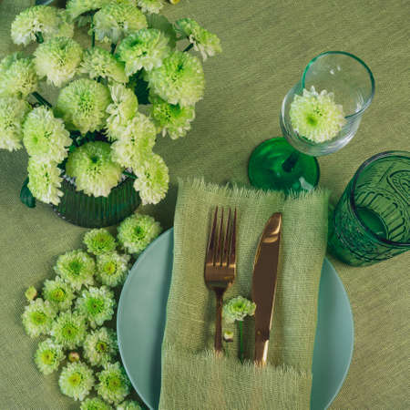 Spring table setting in green tone with flowersの写真素材