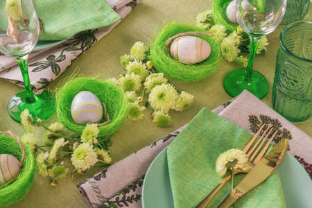 Set table with Easter decoration - eggs in nests and flowers.の写真素材