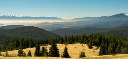 View from the side of Lake Belmeken to the Rila mountains and the peaks of the Pirin mountains in the fogの写真素材