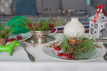 New Years table setting with linen tablecloth, candles and spruce branches