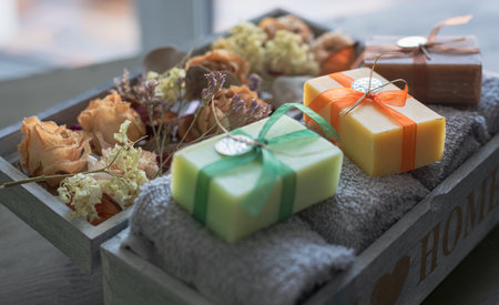 Handmade soap in a wooden box with towels and dried flowersの写真素材