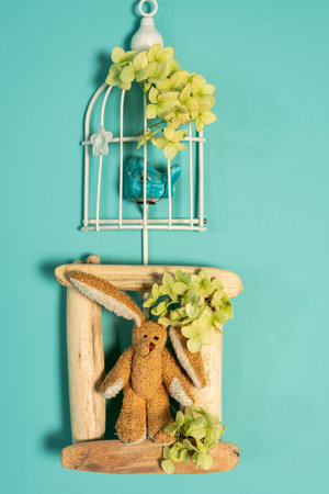 Easter decorations on the wall - a bird in a cage and a hare in a wooden frameの写真素材