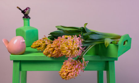 Bouquet of yellow-orange hyacinths on a green stand with spring decorationsの写真素材