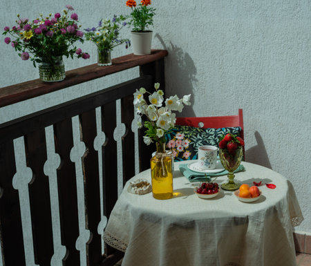 Morning tea with flowers and fruits on the terrace of a country house.の写真素材