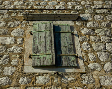 Closed old wooden shutters of a mediterranean stone house. Vintage background.の写真素材