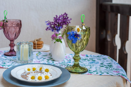 Table on the terrace with soft drinks, flowers and a plate of daisiesの写真素材