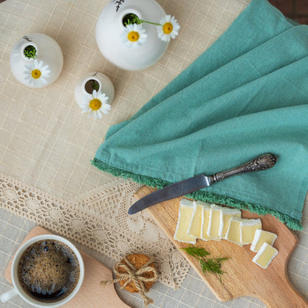 Breakfast - a cup of coffee, cookies and bru cheese on a cutting wooden boardの写真素材