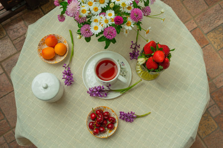 Morning tea with flowers and fruits on the terrace of a country house. Flat layの写真素材