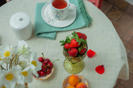 Morning tea with flowers and fruits on the terrace of a country house.の写真素材