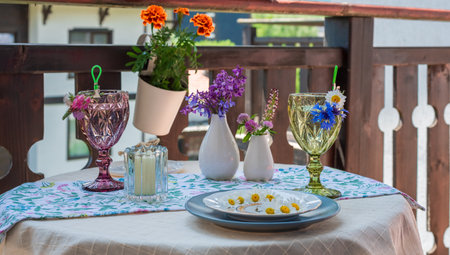 Table on the terrace with soft drinks, flowers and a plate of daisiesの写真素材