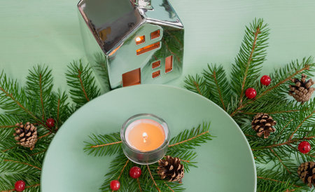 Fir branches with cones, berries and candles on the table, turquoise color.の写真素材