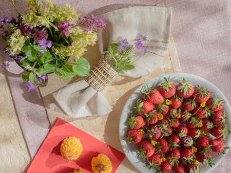 Spring forest flowers, strawberries and napkin on the tableの写真素材