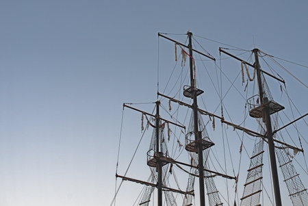 View of a ships mast against a bright blue sky