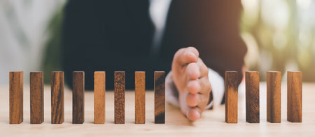 protection and risk management, Financial risk management ,Business Investment Feasibility Assessment, protection of business interests, Human hands blocking wooden sticksの写真素材