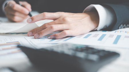 Advertising specialist read business statistics chart reports, to analyze and improve corporate strategy, manage financial and marketing documents, update annual budget accounts, company growth data.の写真素材