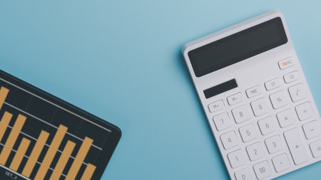 Calculator placed on a blue background ,Calculating numbers from documents and financial graphs of companies ,analysis of company financial data ,concept of finance and investment ,top viewの写真素材