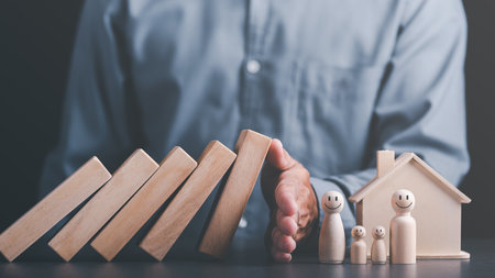 Human hand blocking wooden blocks,Represents protection and protection of safety,concept of insurance management planning To ensure both health and financial safety,Property and Family Risk Reductionの写真素材