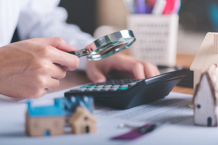 man holding magnifying glass,concept of a loan for housing,Approval of credit for the purchase of real estate,business and finance concept,home loan refinancing,Residential sale and mortgage planningの写真素材