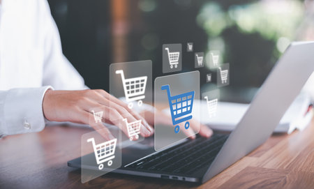 Man using laptop and shopping cart icon,Consumer society,shopaholism concept,Shopping service on The online web and offers home delivery,Connecting merchants and customers around the worldの写真素材