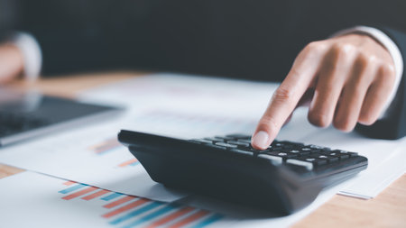 Business people use calculator to calculate documents, profit and loss statement review concept of...