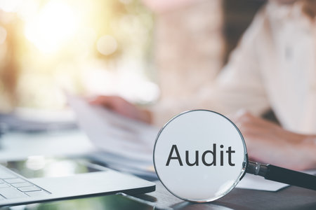 A magnifying glass is on the table,Audit Document Concepts, quality assessment management With a...