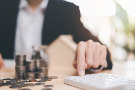 Real estate agent calculates numbers on financial documents with calculator, interest rate calculation,Investment loans for building residential homes, real estate business , Mortgage and bank loansの写真素材