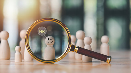 magnifying glass and wooden doll on table,HRM or Human Resource Management,strategic planning for success,developing people to be more efficient,choosing professional leaders based on their abilitiesの写真素材