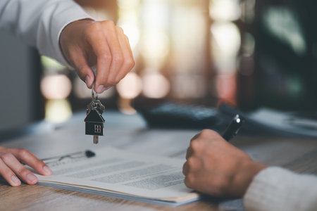 keys in the hand of a real estate agent,Investment loan approval concepts to build residential homes, real estate business, investment savings, mortgages and bank loans, future retirement planning.の写真素材
