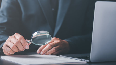 Businessman holding a magnifying glass,Audit Document Concepts, quality assessment management With a checklist, business document evaluation process, market data report analysis and consultingの写真素材