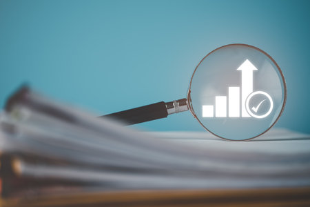 A magnifying glass is placed on the document,Show business growth and success graph. concept of progress in development Financial efficiency and investment with business strategies for goals.の写真素材